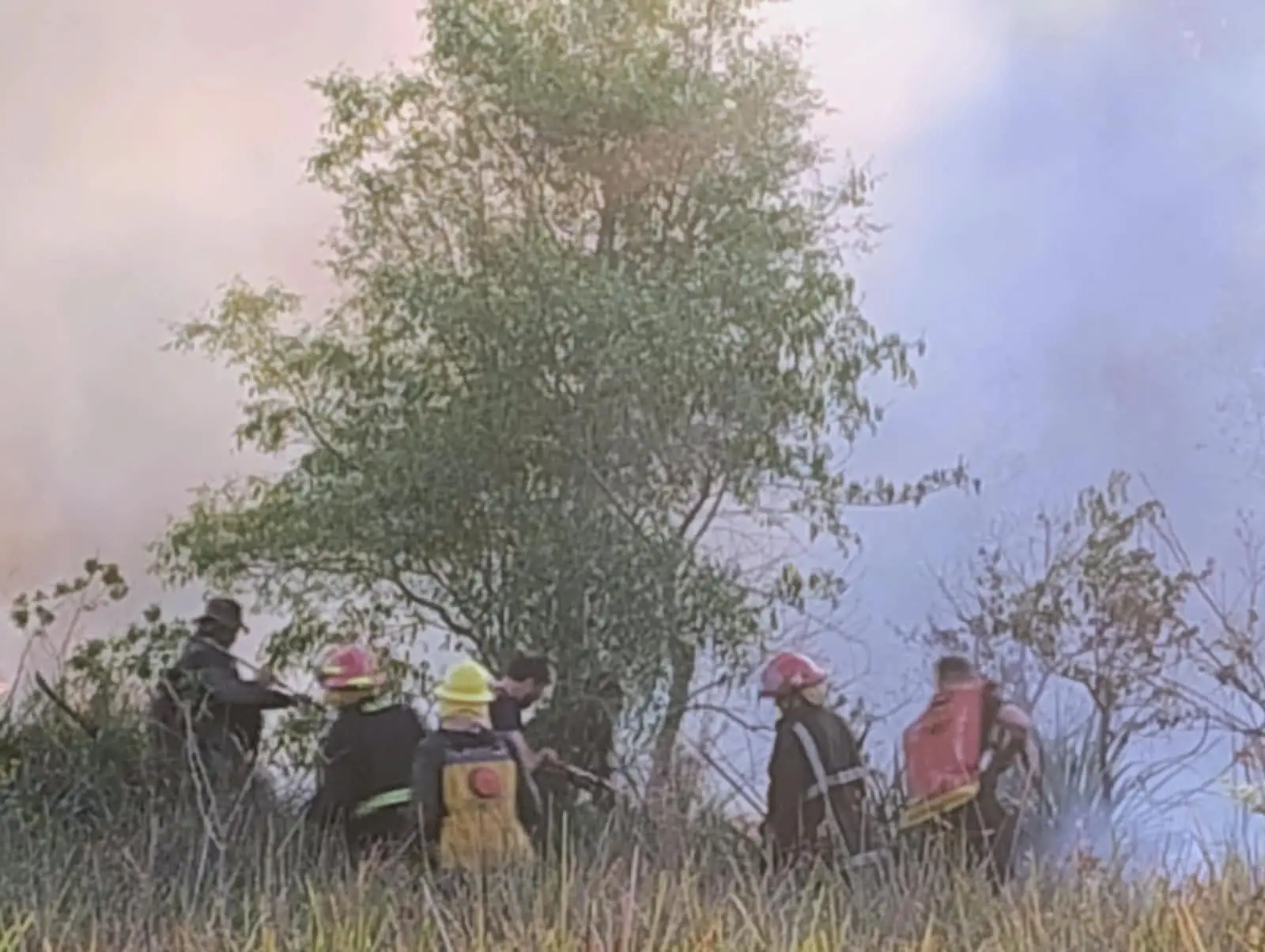 Bomberos voluntarios combatiendo el incendio entre el humo en Teyú Cuaré